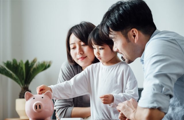 Parents reviewing their household budget together at the kitchen table